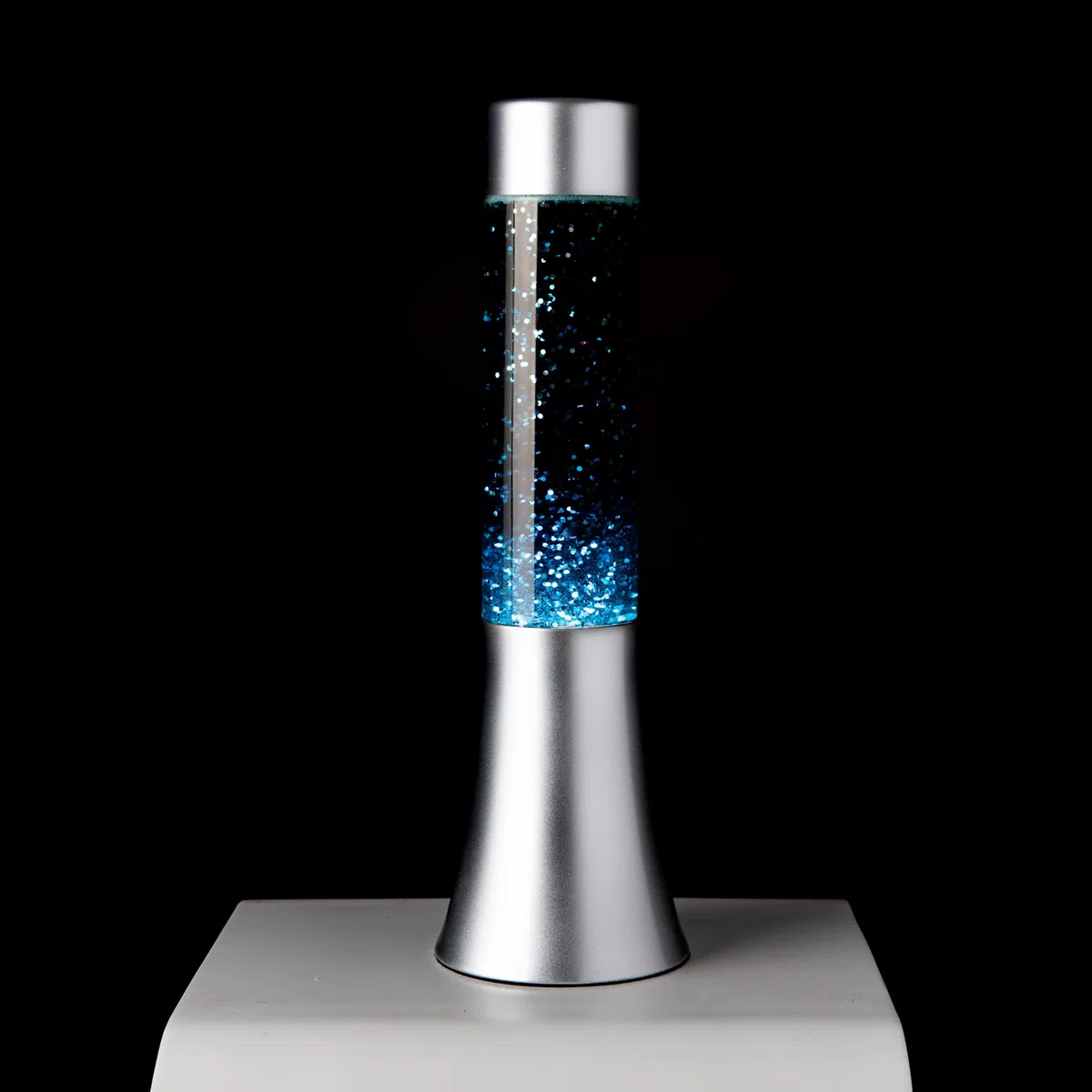Fisura - Lampada lavica blu glitter. Lampada di lava da 30 cm con base argentata, liquido blu e glitter. Lampada ad effetto rilassante. 9x9x30 cm